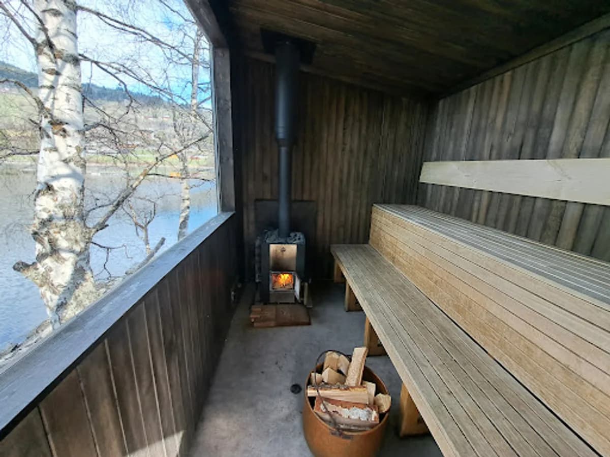 Interiør av Badstugu badstue i Ål med vedfyrt ovn og utsikt over Strandafjorden