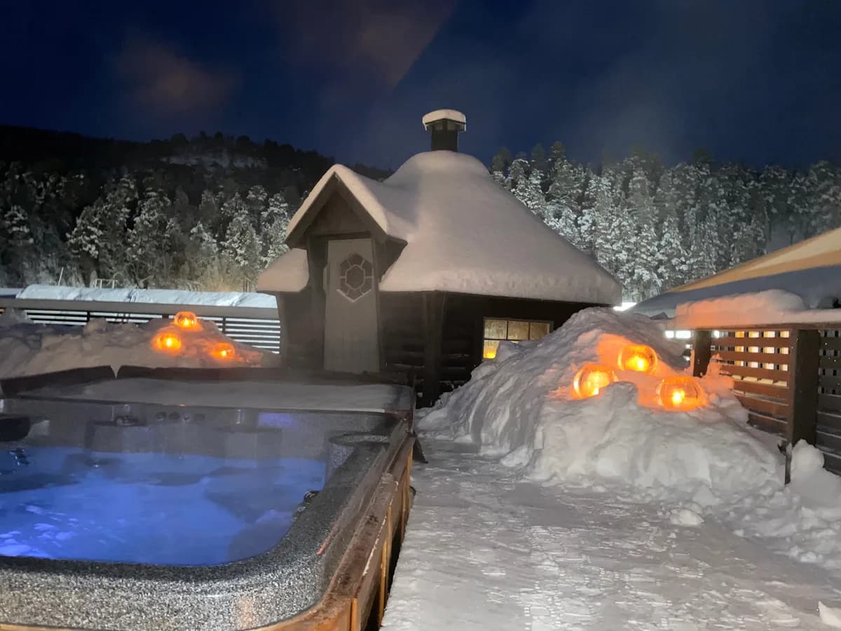 Utendørs boblebad og badstue ved Sorrisniva Igloo Hotel i Alta, vinterlandskap med snø
