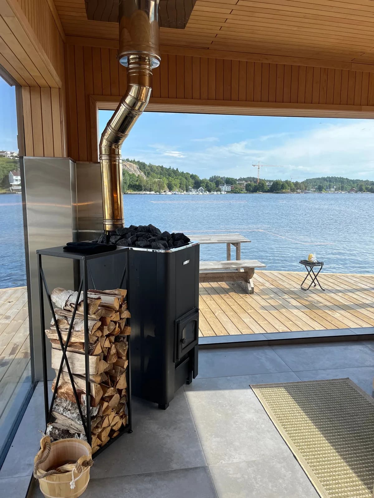 Vedfyrt ovn med utsikt over vannet fra Biestø Båt Badstue i Arendal