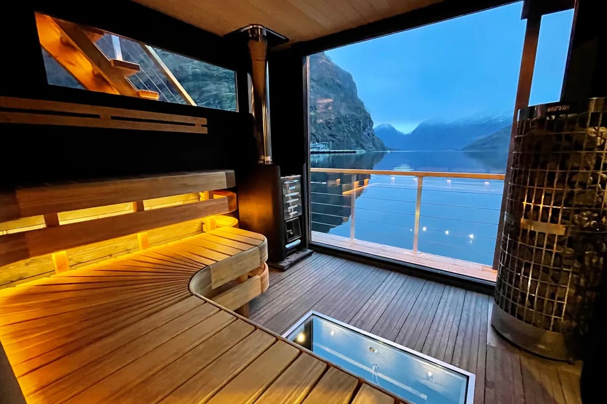 Interiør av FjordSauna Aurland med panoramavinduer og fjordutsikt i kveldslys