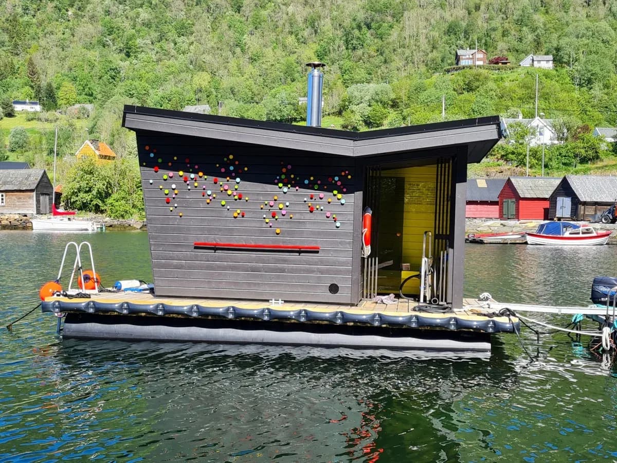 Flabellina Kunstbadstove flytande badstue på fjorden i Mjøsvågen med fargerike prikkar på fasaden