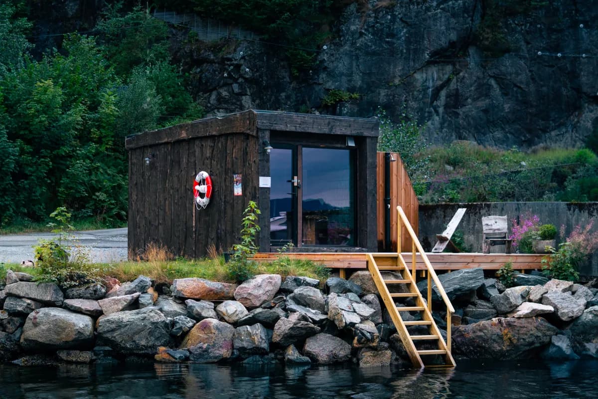 Kjøkkelvik Badstue sett fra sjøen med tretrapp og fjord i Bergen