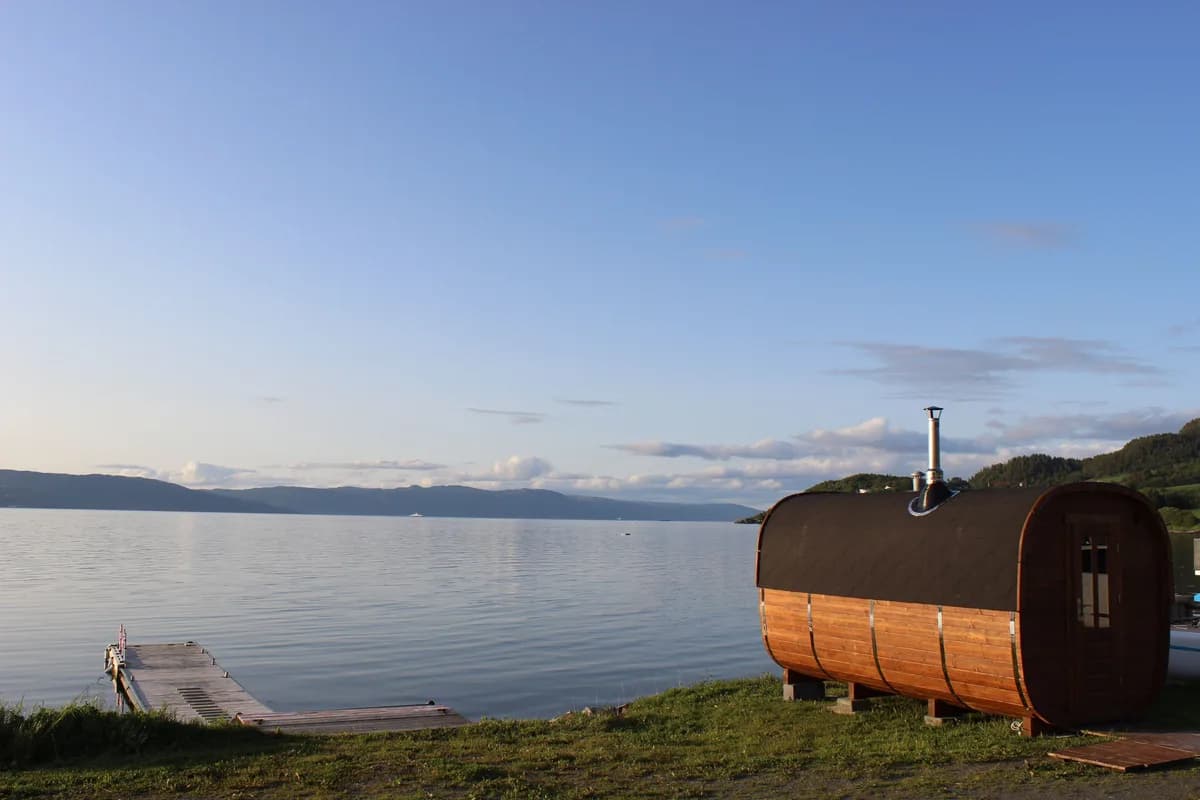Damp Rydja badstue ved vannkanten i Bosberg med utsikt over fjorden i solnedgang