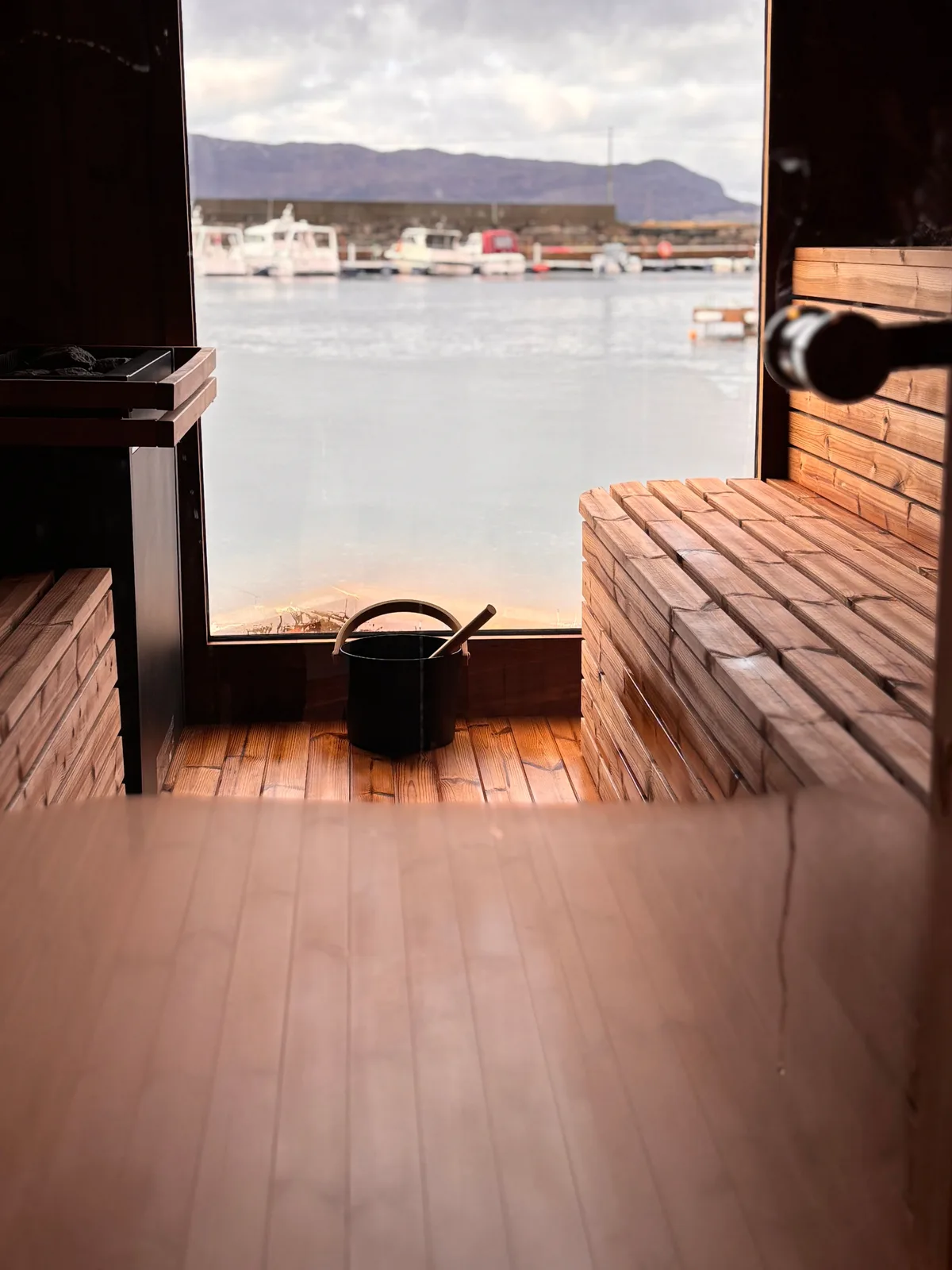 Interiør i Brim Fjordsauna i Bremanger med trebenker og utsikt over fjorden