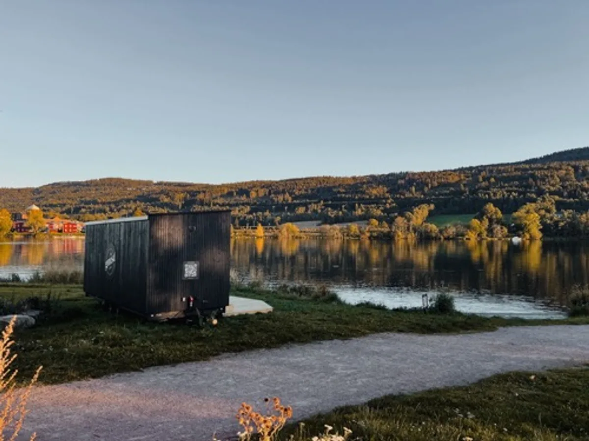 Gnist Sauna i Drammen ved Drammenselva med høstfarger og fjell i bakgrunnen