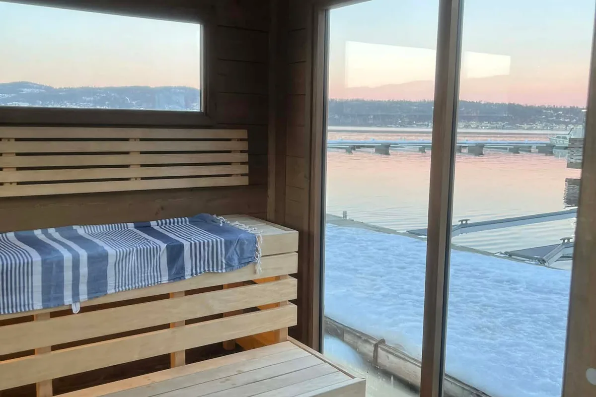 Interiør i Nøsted Brygge Badstue i Drammen med trebenker og utsikt over fjorden
