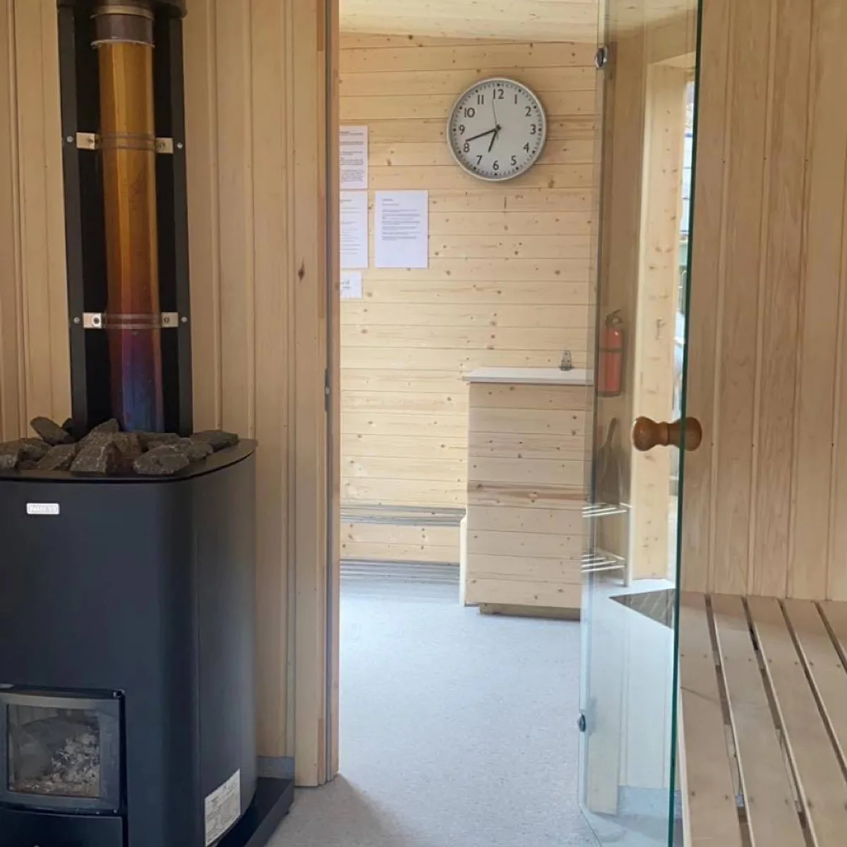 Interiør av Eikelandsfjorden Sauna med vedfyrt ovn og trebenker i Eikelandsosen