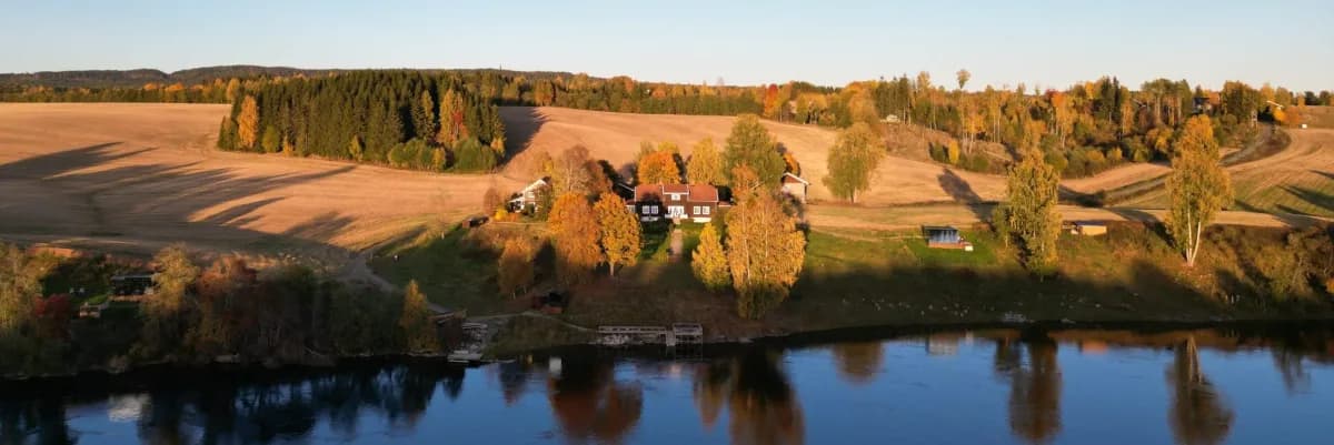 Flyfoto av WonderInn Riverside ved Vorma-elven i Fenstad med høstfarger