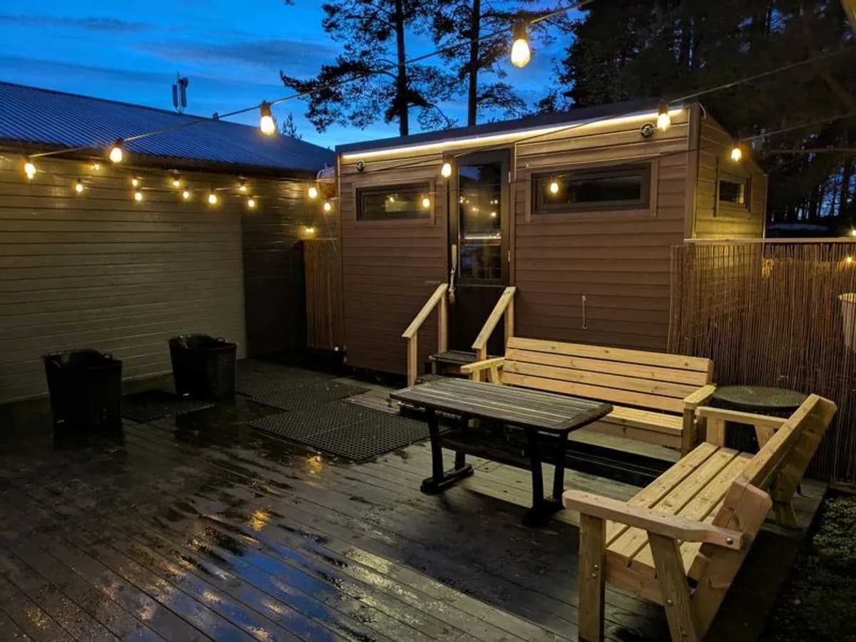 Vedfyrt badstue med lyslenke på kveldstid hos Gamle Fredrikstad Badstu og Bad