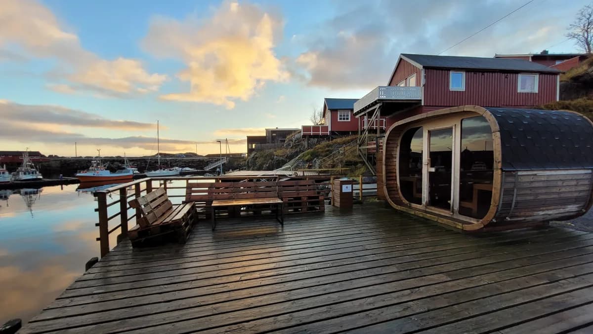 Tønnebastu på trebrygge ved havnen i Hamnøy med rorbuer i bakgrunnen