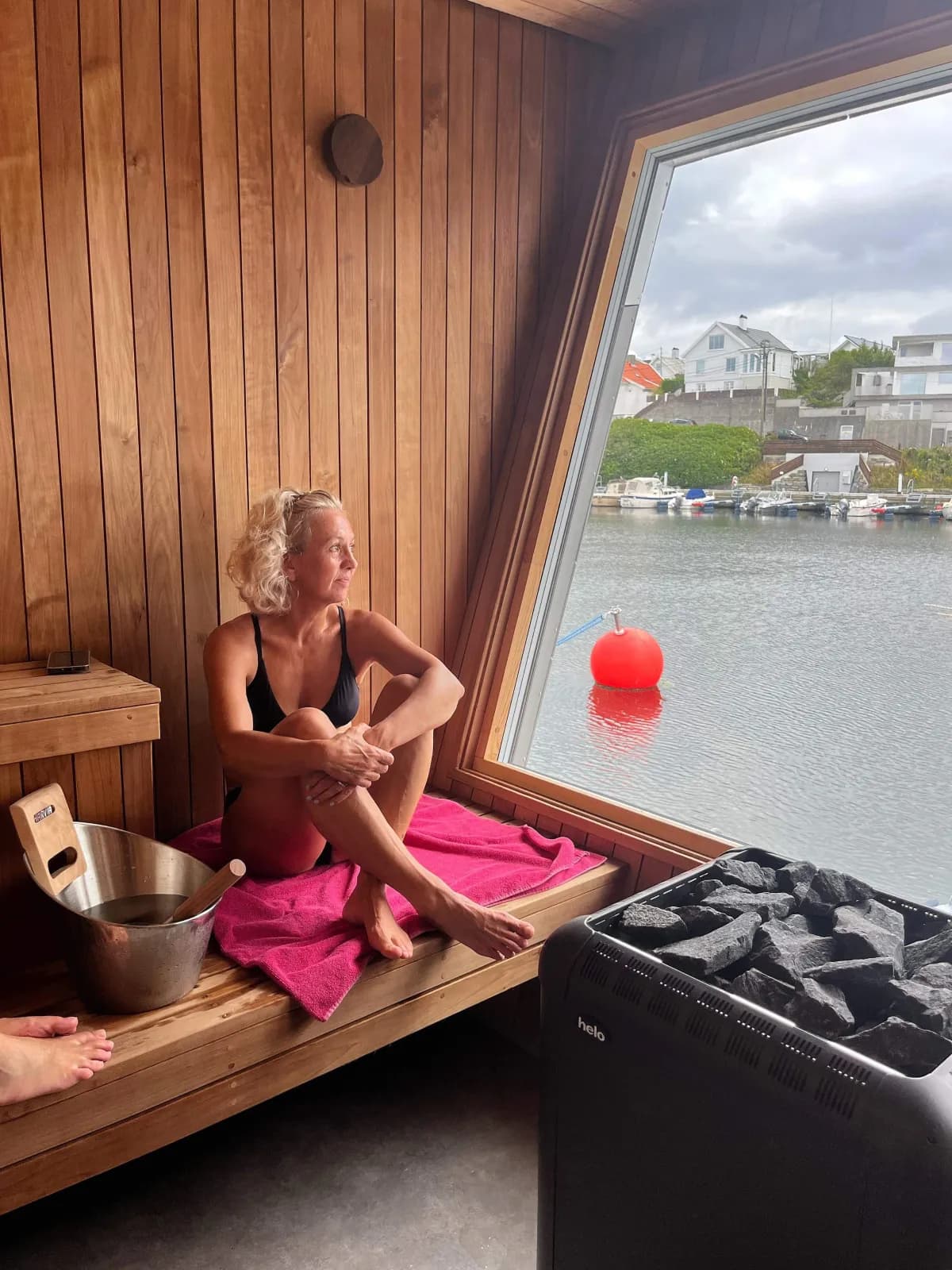 Interiør i Losen Badstue Haugesund – person sitter i saunaen med utsikt mot sjøen