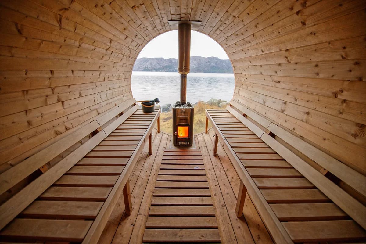 Interiør i Damp Isla badstue i Hjelmeland med vedfyrt ovn og utsikt over fjorden