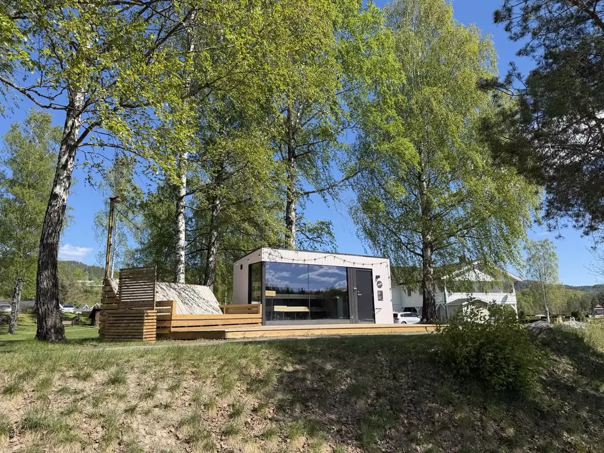 Gnist Sauna-bygget i Hokksund sett fra plenen med bjørketrær foran