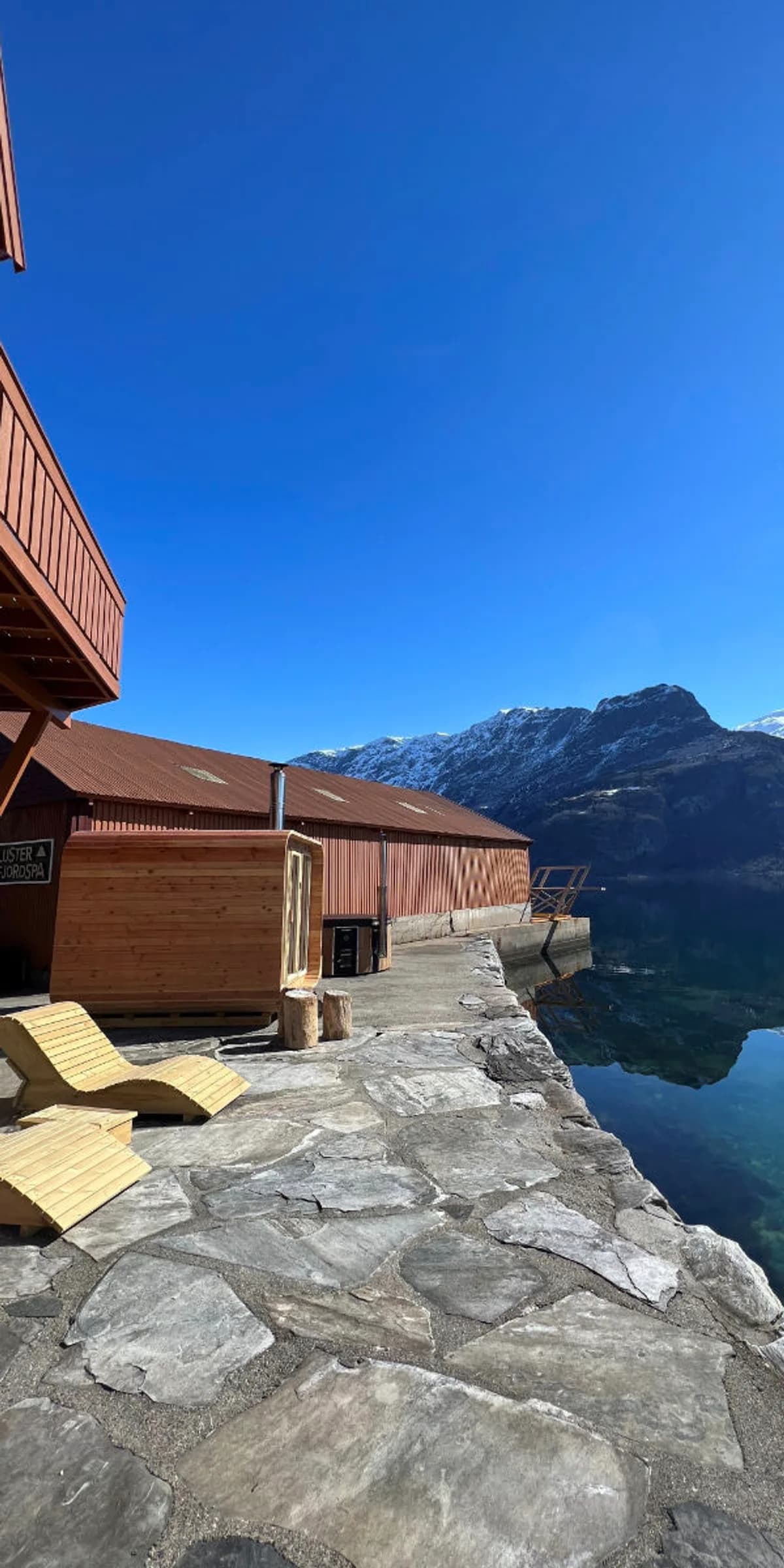 Luster Fjord Spa i Høyheimsvik, utendørs spaområde med solsenger ved fjorden og fjellutsikt