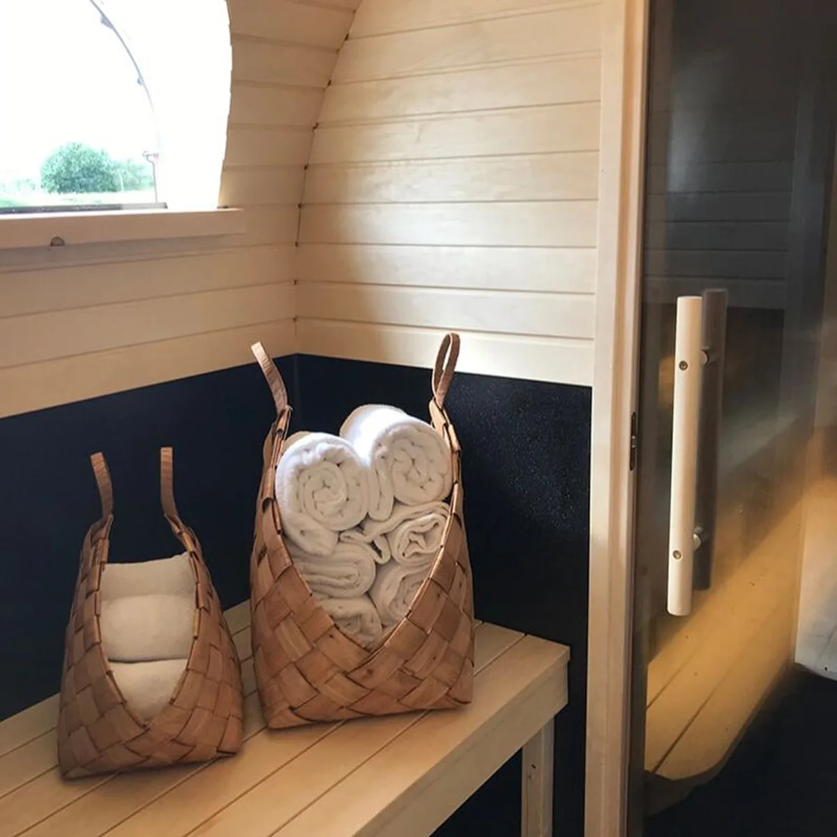 Interiør i Saga Sauna i Inderøy med håndklær i flettede kurver på trebenk