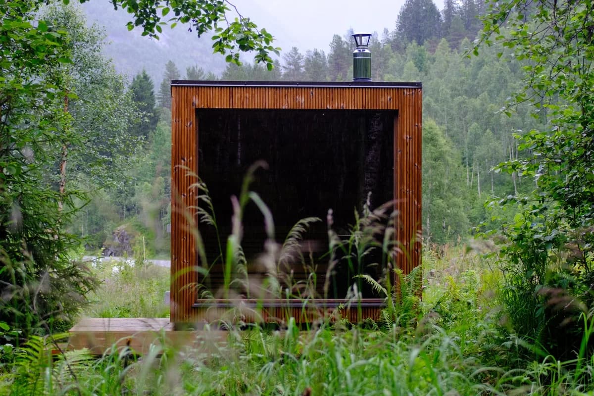 Jostedal Sauna sett utenfra, moderne trebygning omgitt av frodig skog i Jostedalen