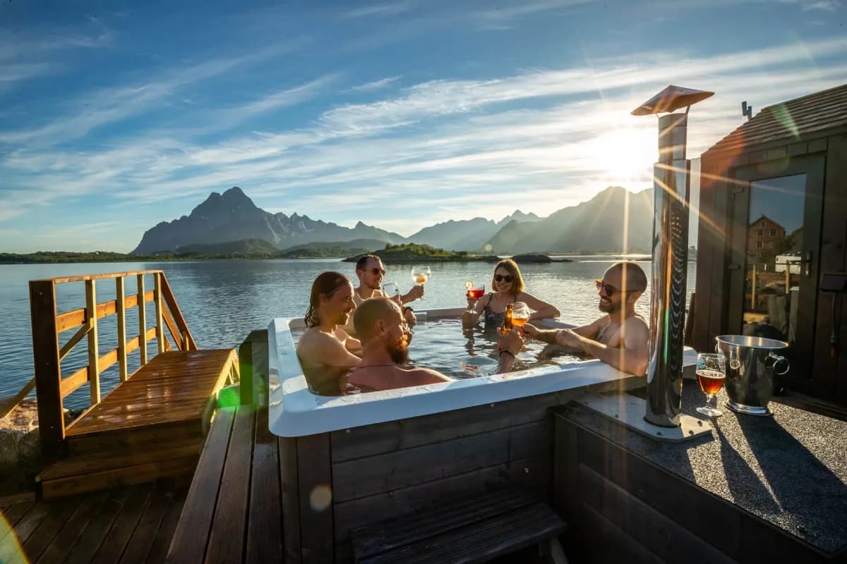 Gjester i jacuzzi ved Skårungen Spa i Kabelvåg med fjordutsikt og fjell i bakgrunnen