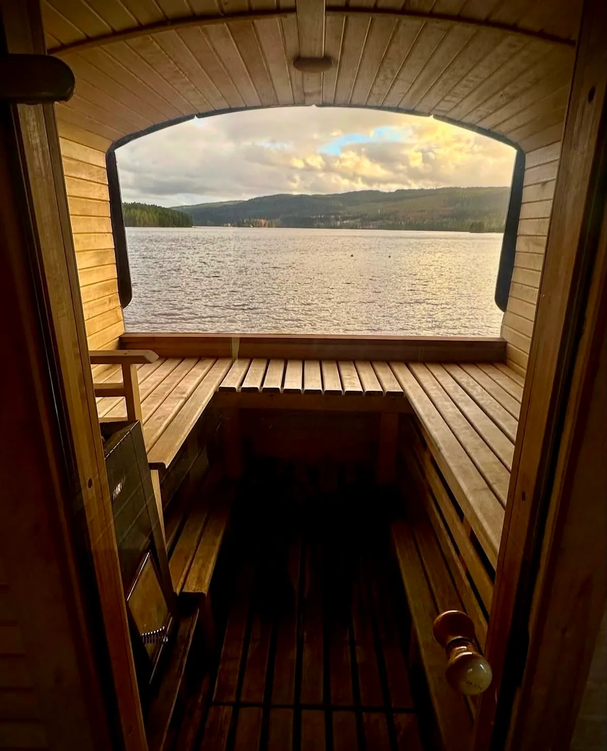 Interiør i Badstuvogna Kongsvinger med trebenker og panoramautsikt over vannet