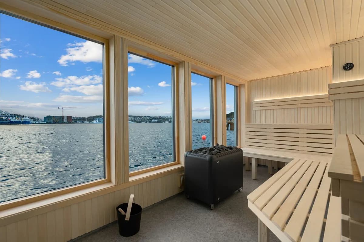 Interiør av Kristiansund Sauna med utsikt over havna gjennom store vinduer