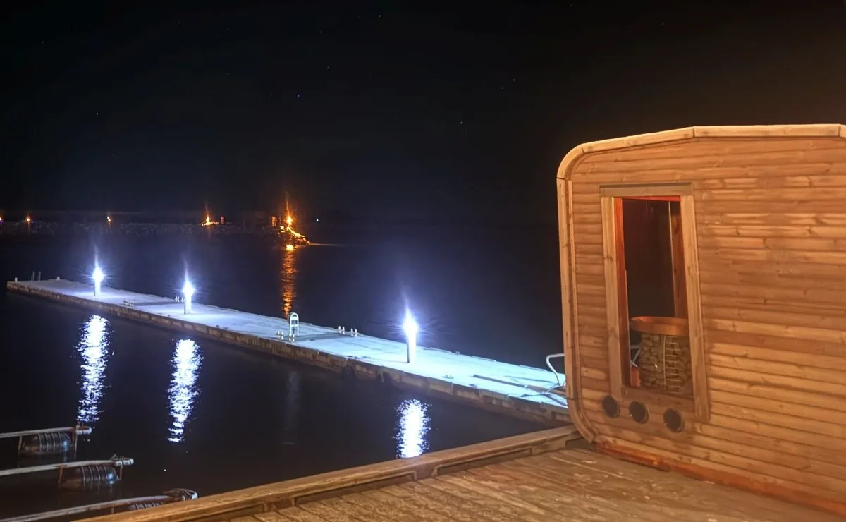 Slappfisken Sauna kveldsstemning Slappfisken Sauna i Helnessund opplyst om kvelden med brygge over sjøen
