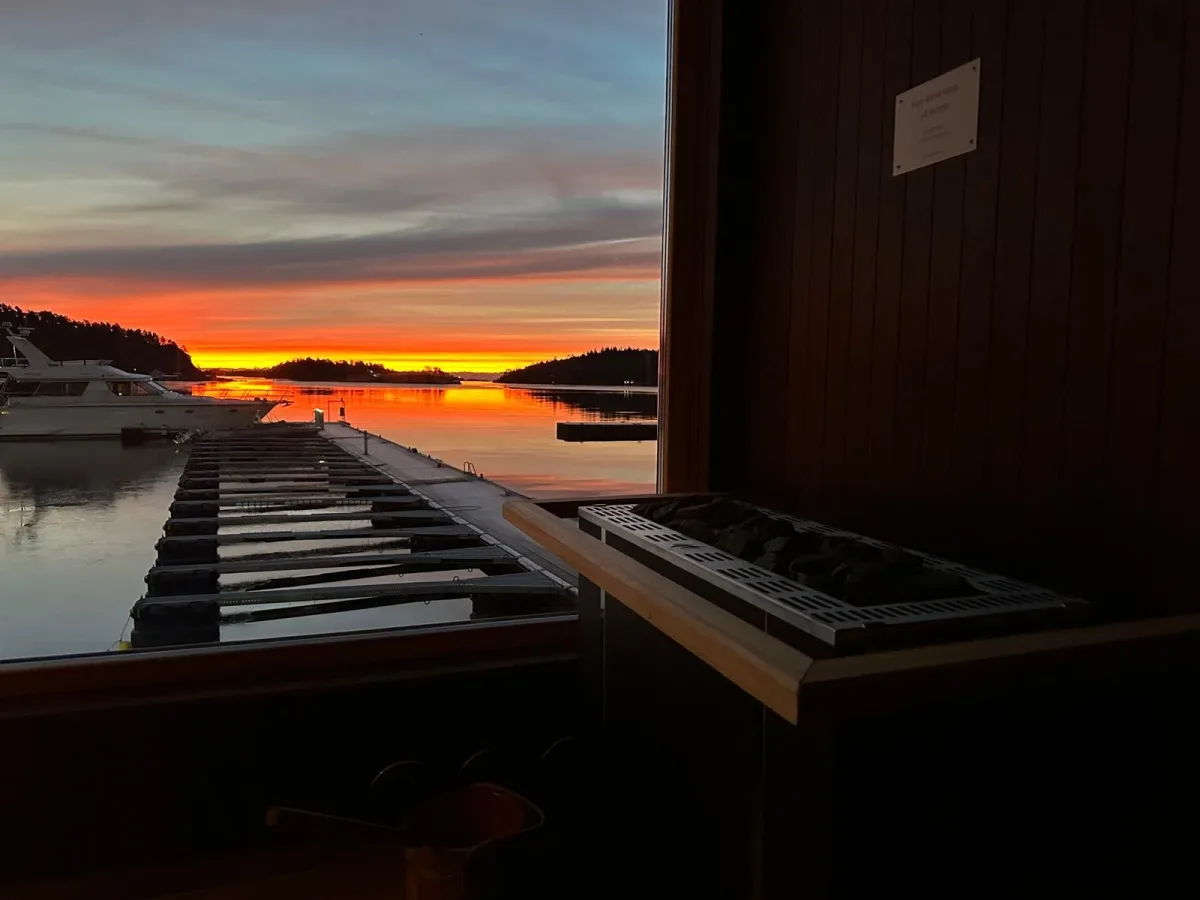 Utsikt fra Smeigedag Sauna i Lillesand med solnedgang over marinaen