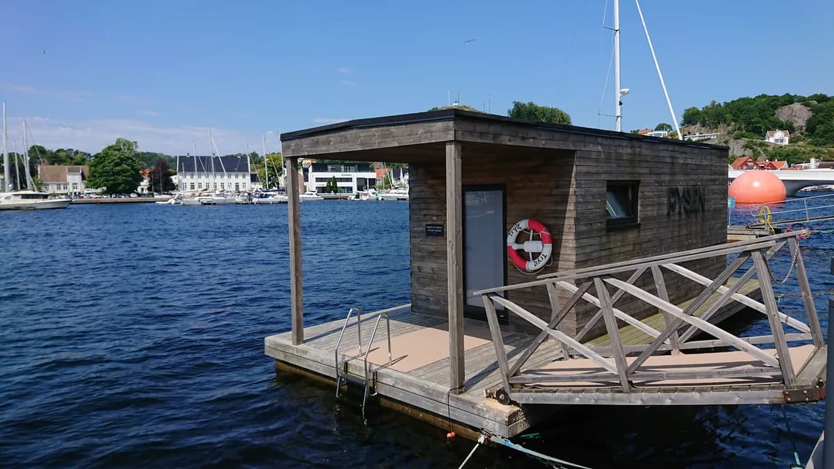 Badstubåten Pysen sett utenfra på Mandalselva i Mandal, med trearkitektur og badeplattform