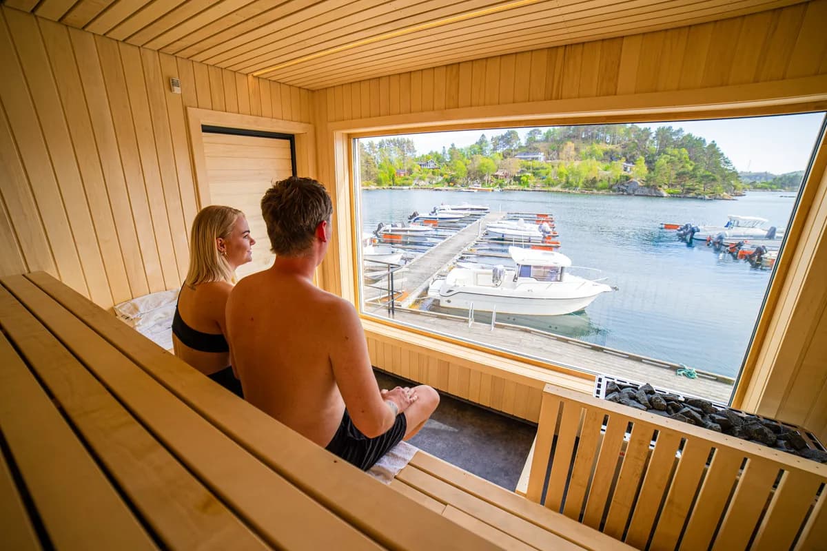 Interiør av Tregde Sauna i Mandal med utsikt over marinaen gjennom panoramavindu