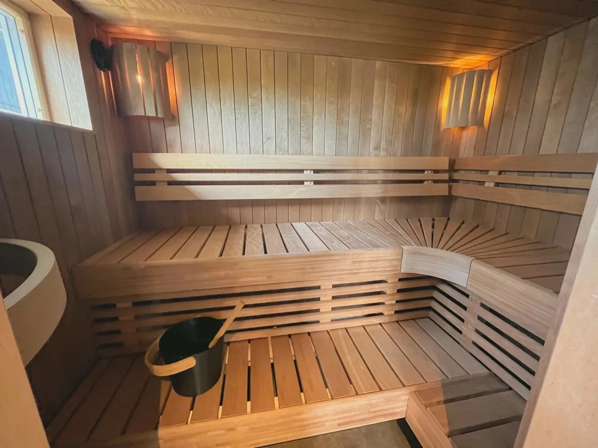 Interiør av badstuen hos Moss folkebadstue Krap Falls med trebenker og varmt lys