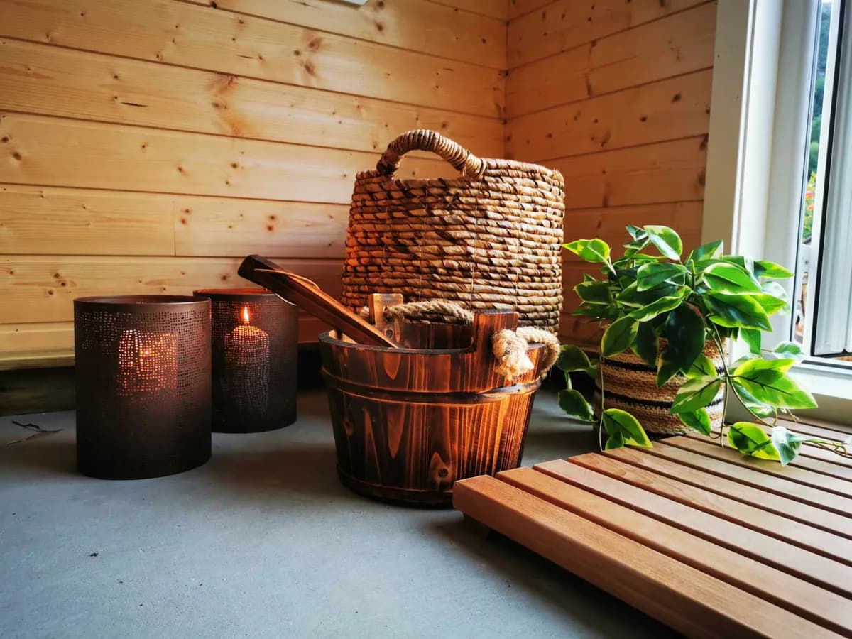 Loungeområde i Bømlo Sauna med levende lys, badstubøtte og planter i Mosterhamn