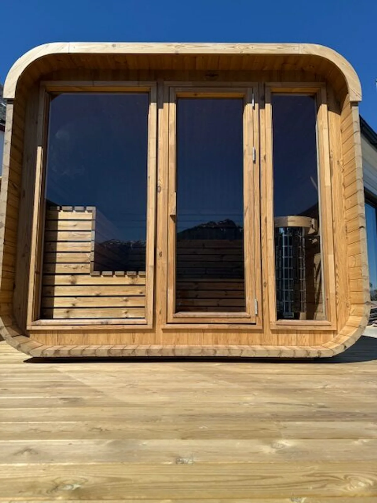 Naa Sauna i Nå – tønneforma badstue i tre med glasfront på brygge ved Hardangerfjorden