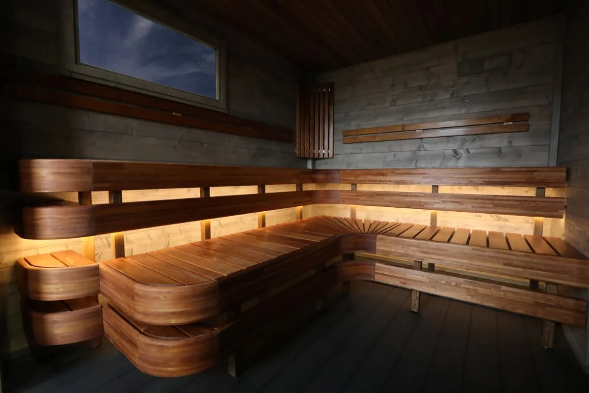 Interiør av Sjøbris Sauna i Ørsta med trebenkar og varm belysning