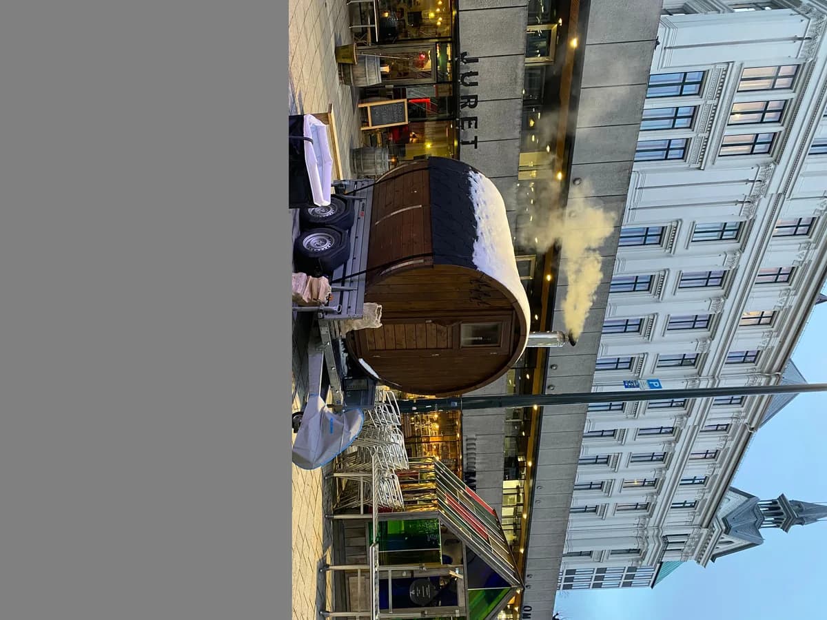 Badstutrollene mobil tønnebadstu på tilhenger i bygate med damp fra pipa, Oslo