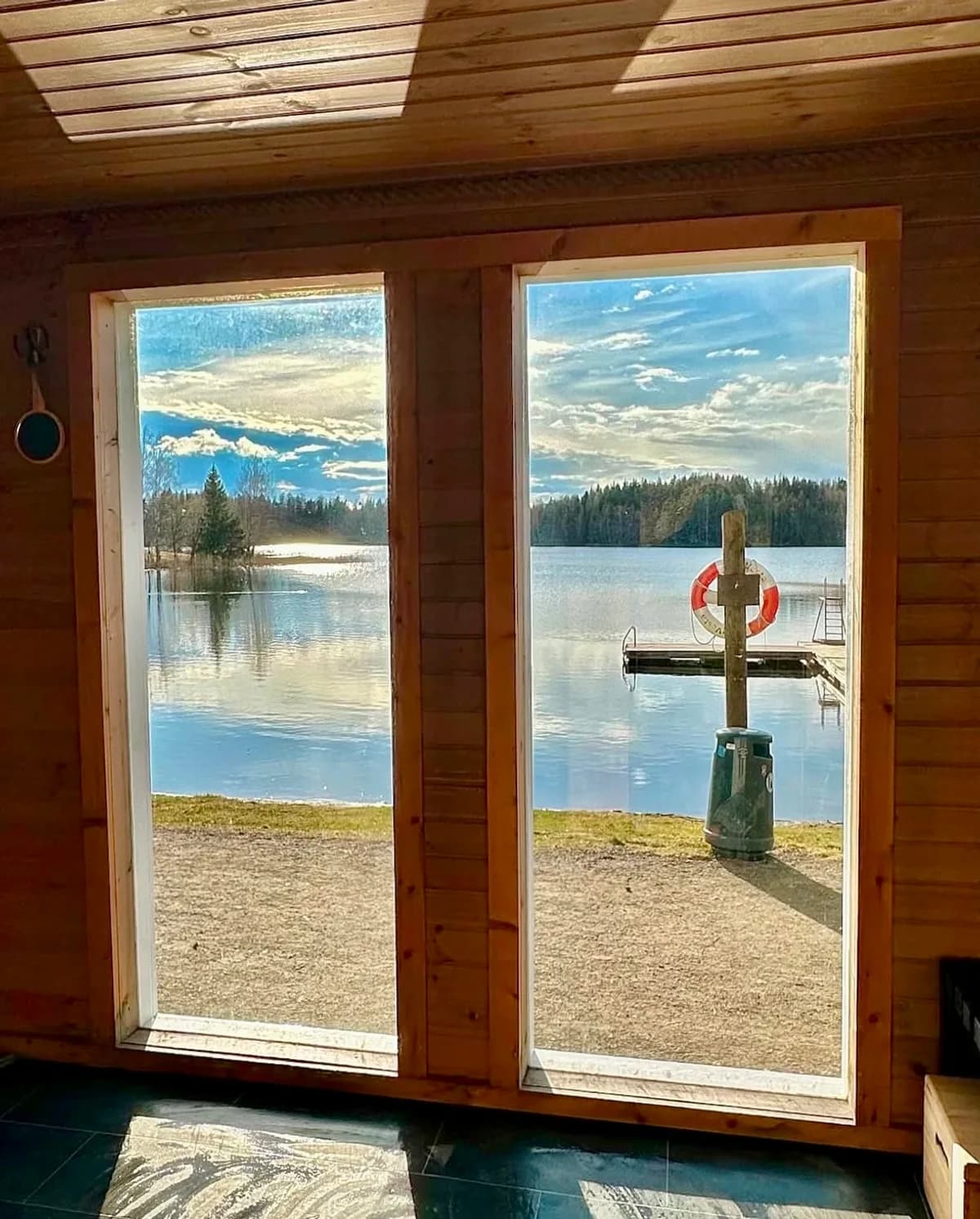 Utsikt fra Badstuvogna Jessheim over Nordbytjernet gjennom glassdører i badstuen