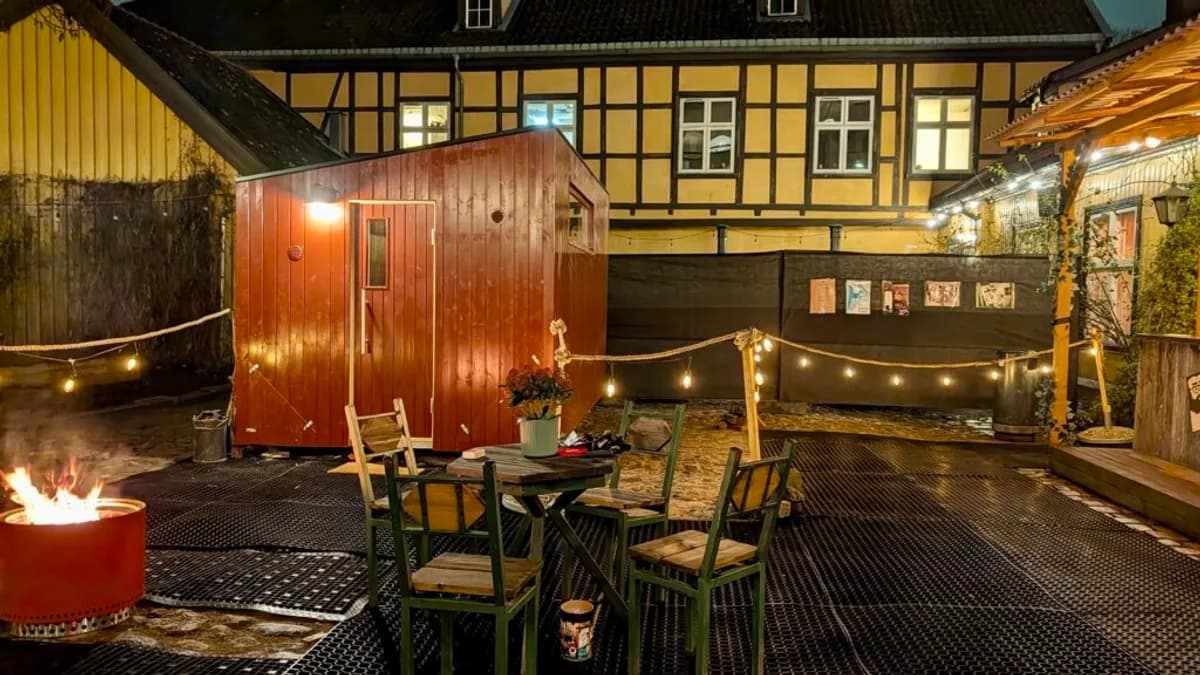 Bakgården hos Folk i Storgata i Oslo med vedfyrt badstue, lyslenker og bålpanne