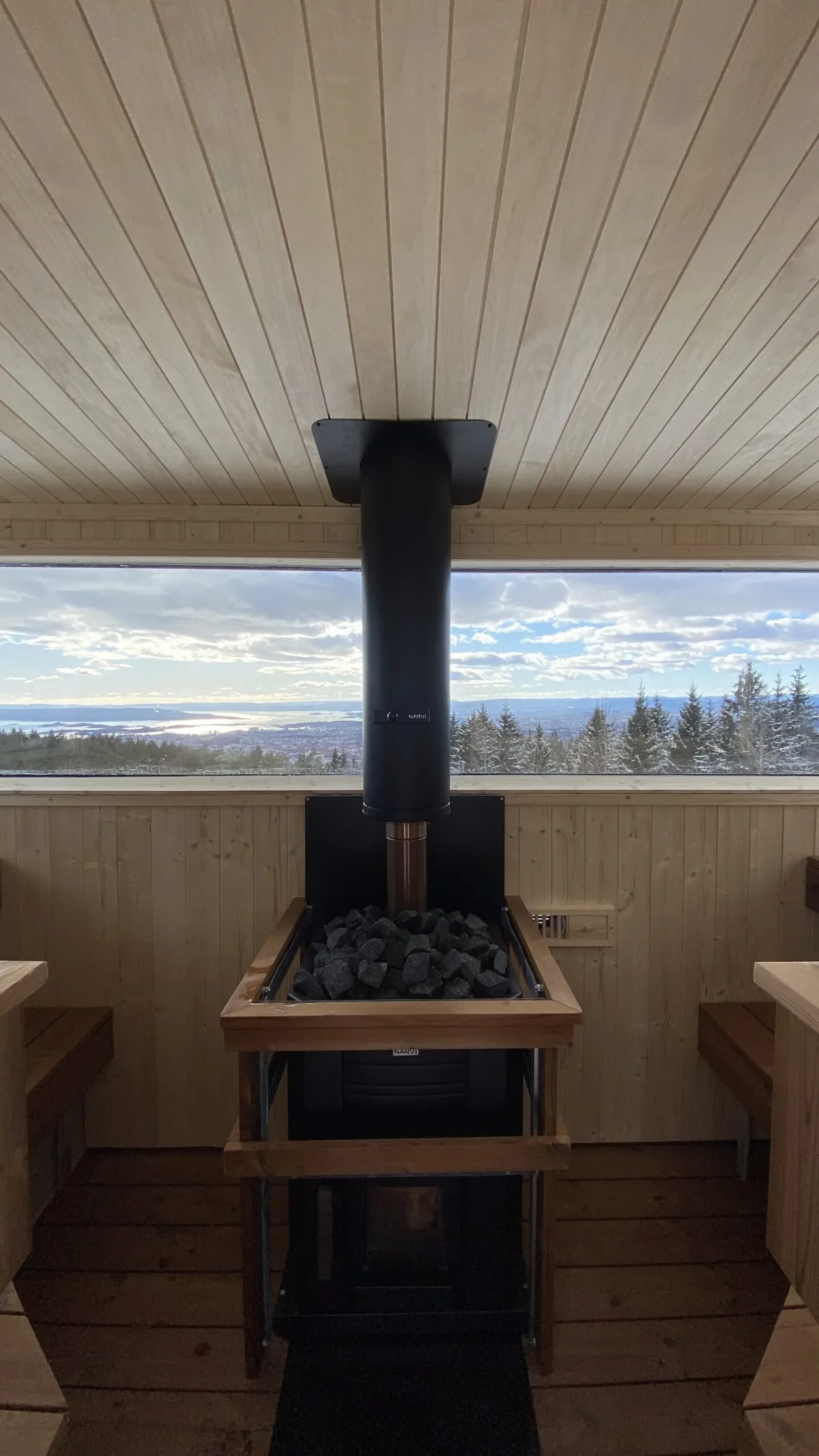 Vedfyrt ovn inne i badstua Sidensvansen på Grefsenkollen med utsikt over Oslo