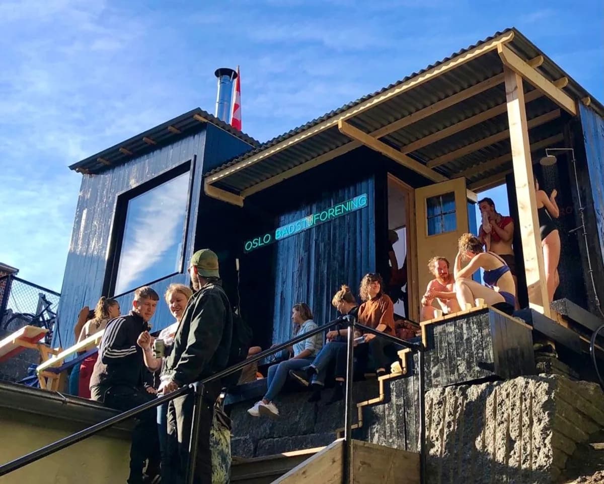 Kroloftet badstue i Oslo med Oslo Badstuforening-skilt og gjester på terrassen en sommerdag