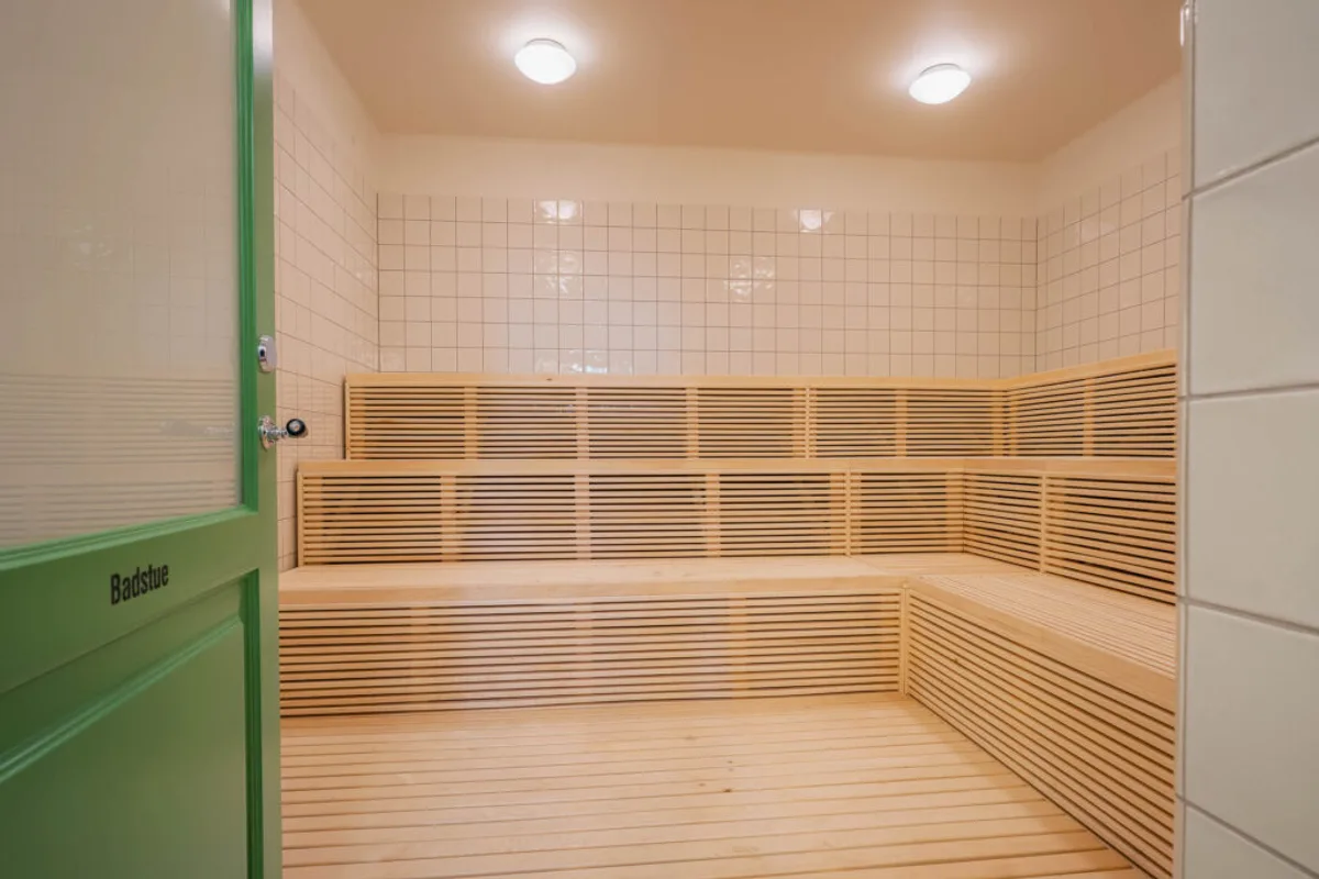 Badstuen i Sagene Folkebad Badstue med trebenker og grønn dør inne i Sagene Folkebad i Oslo
