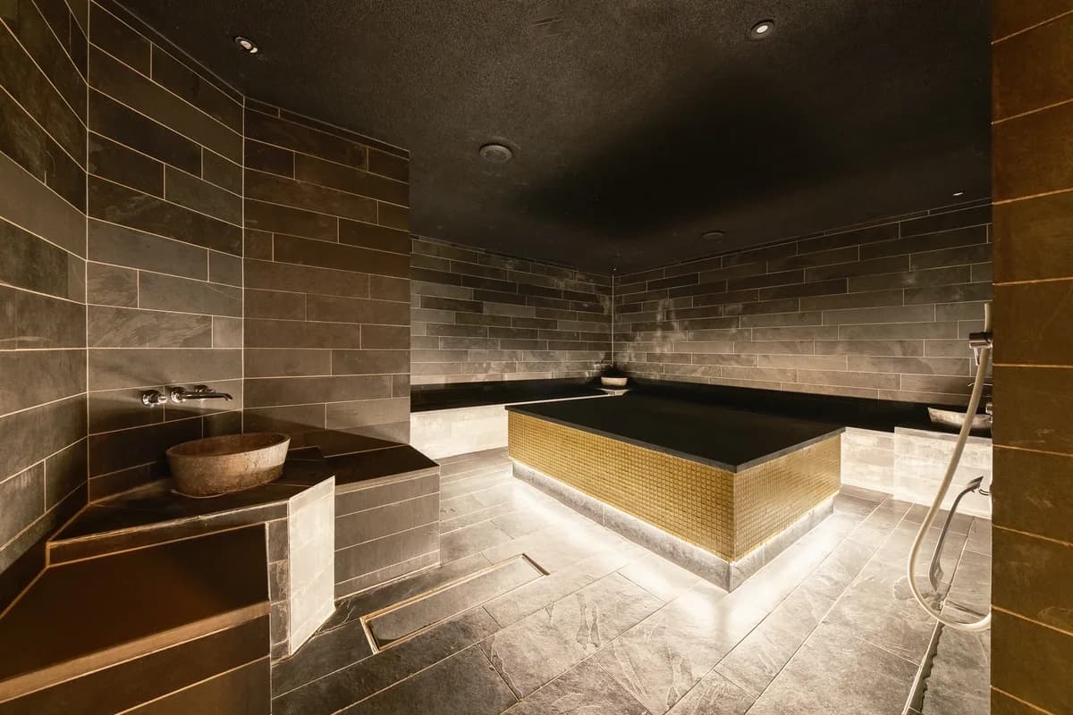 Hamam med steinvegger og gullmosaikk-basseng hos Thief Spa i Oslo