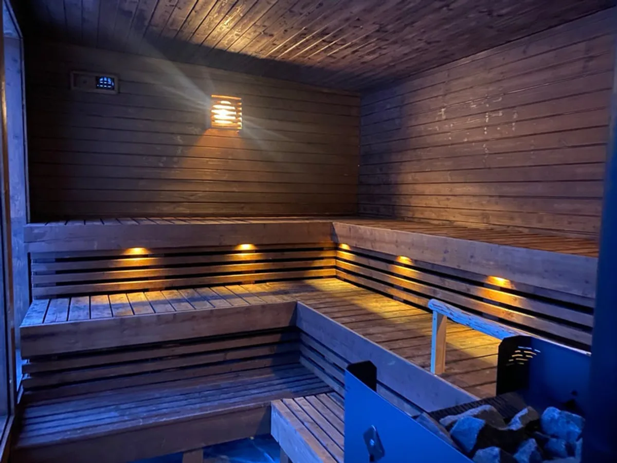 Interiør i Sjøterrassen Sauna med trebenker og stemningsfull belysning, Stathelle