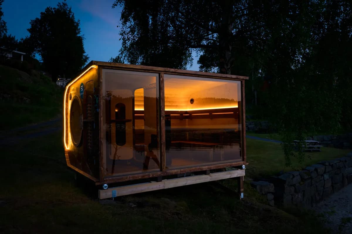 Aurora Sauna i Risør opplyst om kvelden med glass-front og varmt lys