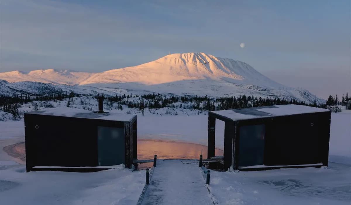 To flytende badstuer på Kvitåvatn med Gaustatoppen i bakgrunnen, vinterlandskap i Rjukan