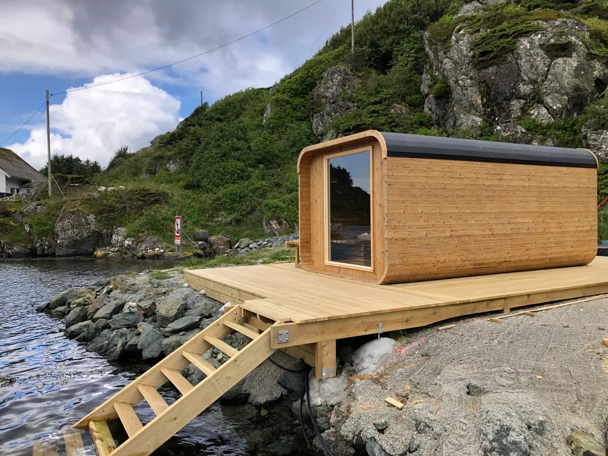 Badstue ved sjøen på Røvær Kulturhotell med treplatting og badestige til havet