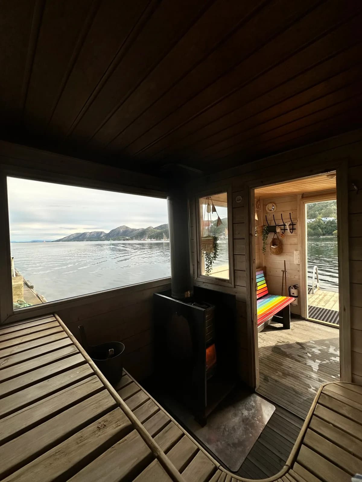 Interiør i Damp Eevi flytende badstu i Sandnes med vedfyrt ovn og utsikt over Gandsfjorden