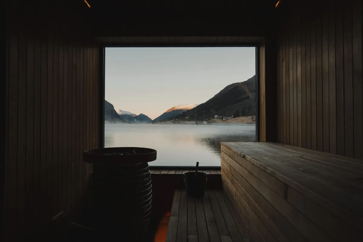 Interiør av Fyrig Sauna på Skei med panoramavindauge og utsikt mot Jølstravatnet i kveldslys