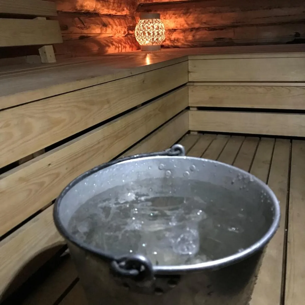 Interiør i Plura Valley Sauna med trebenker og vannbøtte, Skonseng