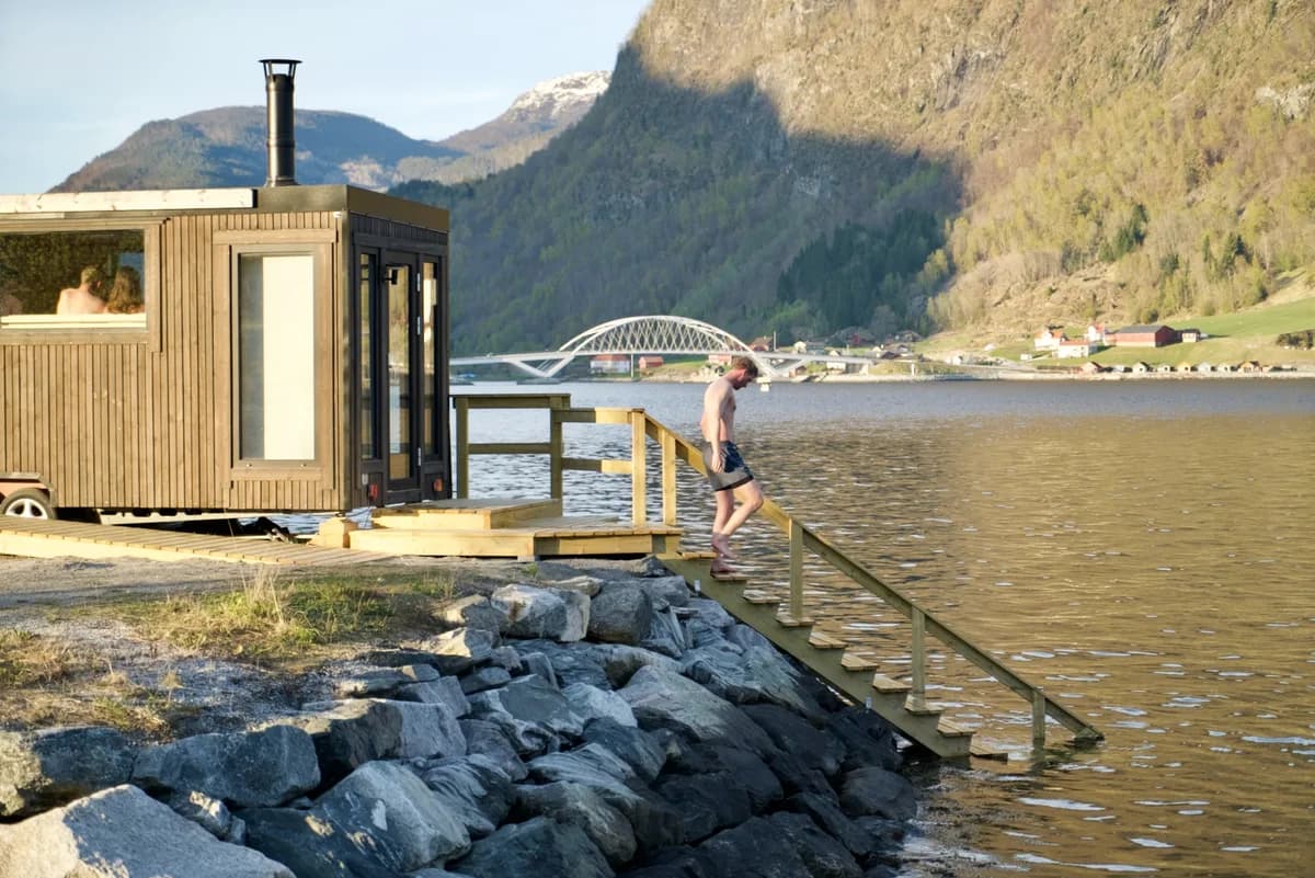 Sogndal Sauna ved Sognefjorden med trapp ned i vatnet og Loftesnesbrui i bakgrunnen