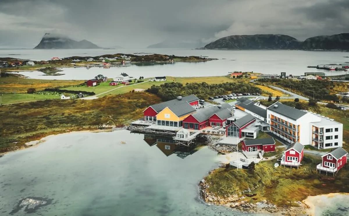 Sommarøy Arctic Hotel sett fra luften med lagunen og fjellene i bakgrunnen, Sommarøy