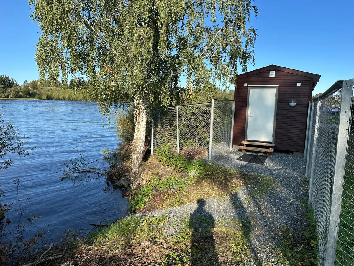 Kuskerudnebben Badstue ved Glomma i Sørumsand med bjørketre og elveutsikt