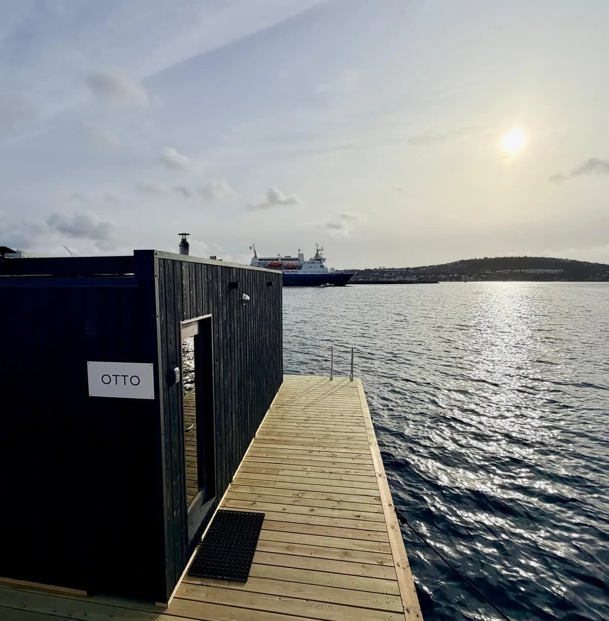 BookSauna Otto flytende badstue sett fra bryggen i solnedgang, Hundvåg, Stavanger