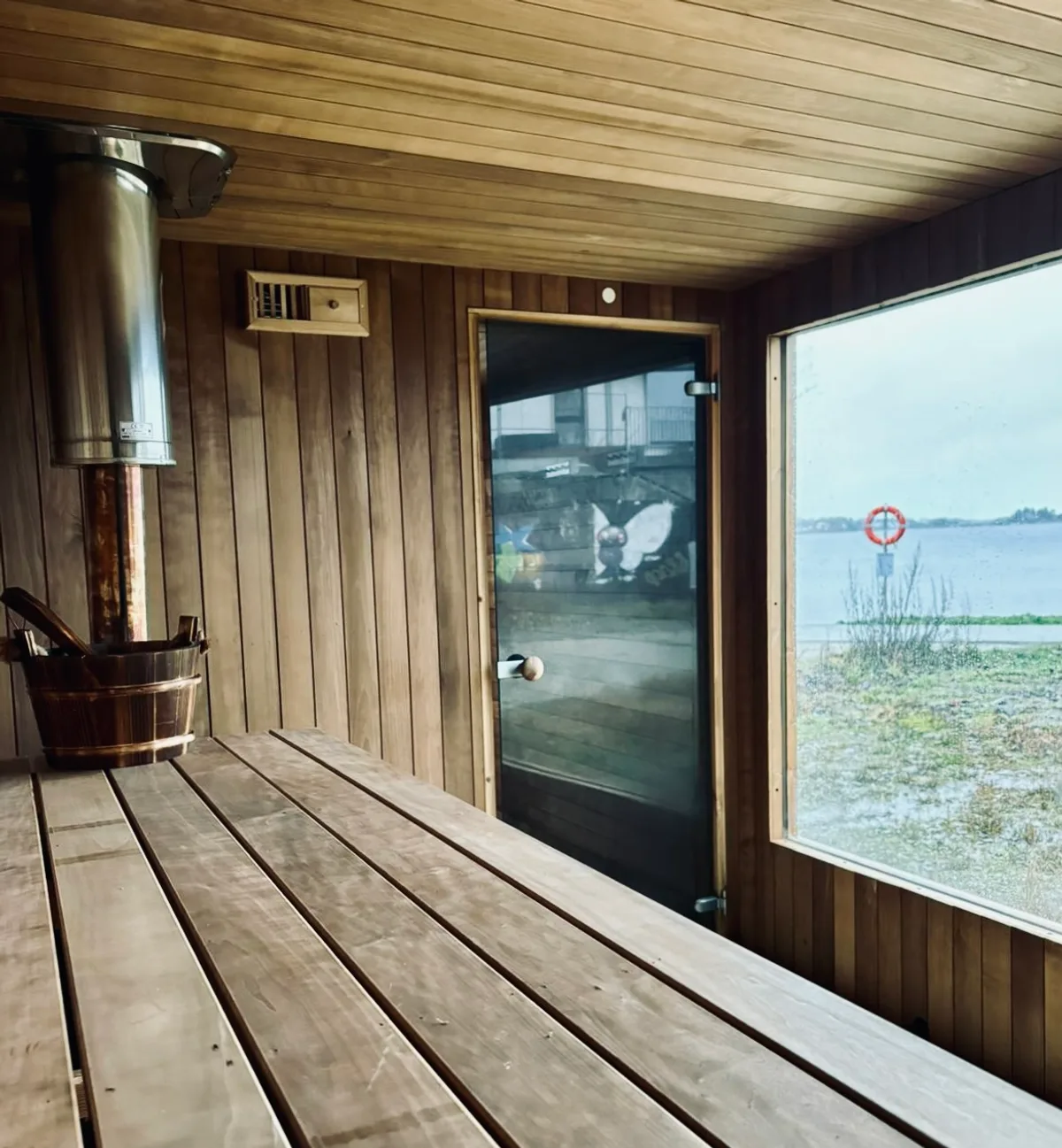 BookSauna Sven interiør Interiør i BookSauna Sven i Stavanger med vedfyrt ovn, trebenker og sjøutsikt